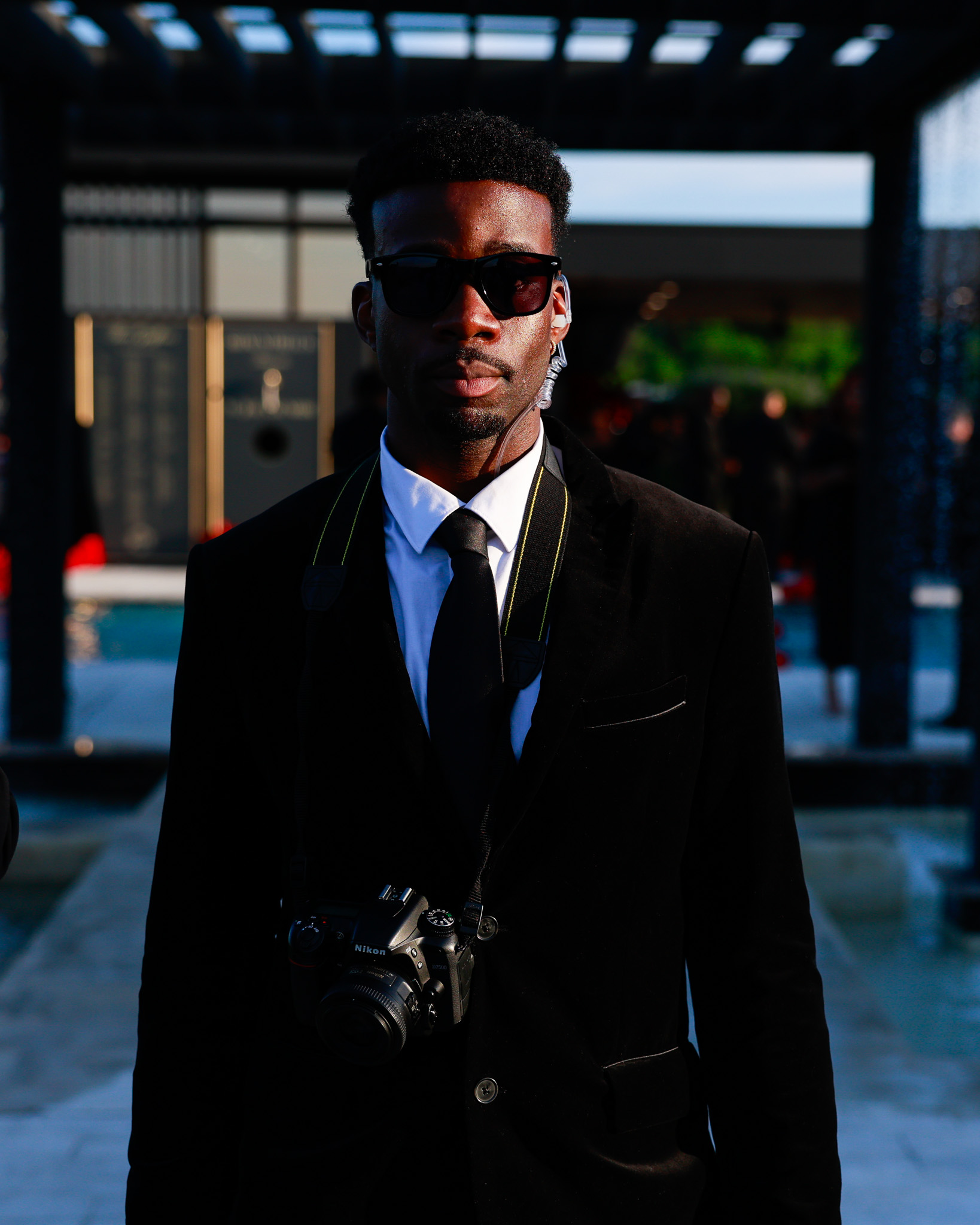 A Paparazzii photographer dressed for an event with a camera